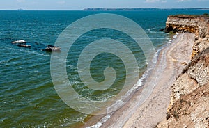 Steep clayey and shell rock shore overgrown with wild steppe vegetation on the island of Berezan, Ukraine