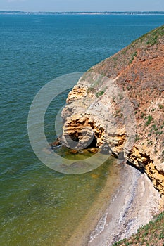 Steep clayey and shell rock shore overgrown with wild steppe vegetation on the island of Berezan, Ukraine
