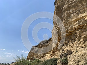 Steep cliff of the mountain by the sea. Sandy mountain by the ocean. A hill near the coast