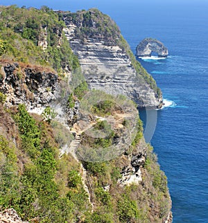 Steep cliff with rocky coastline, natural arch