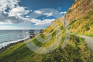 Steep green slope with tourist path. Ireland.