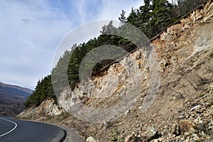A steep mountain descent against the background of a sharp turn of the mountain road