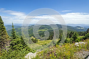 Steep mountain and lake views from the peak of Mt Spokane State Park overlooking the Spokane Washington area on a summer day