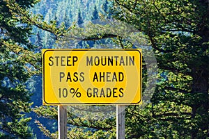 Steep mountain pass traffic warning sign advising motorists of a steep ten percent mountain grade that requires the driver to pay