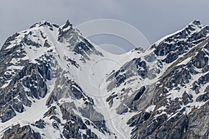 steep mountain with trail of skier