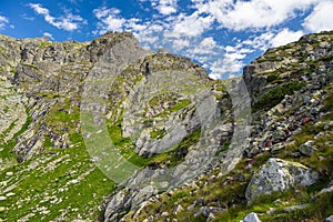 Steep mountains under blue sky with some clouds in summer