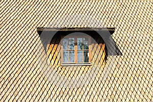 Steep old shingle roof with a window