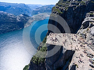 Steep rock Preikestolen over water of fjord Lysefjorden, natural attraction. Top view, flight above cliff. The Preacher`s Pulpit