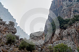 Steep rocky cliffs. Saklikent Canyon or â€œhidden cityâ€ in Turkish. Blurred background. Selective focus. Saklikent National Park