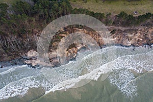 Steep shore with trees and stairs slipped under the influence of rain and wind. Dangerous place. Photographed from above.