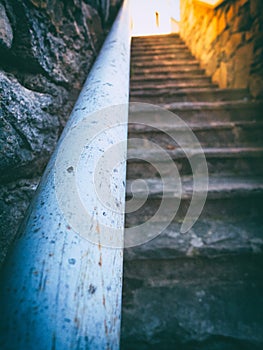 Steep staircase with spotted handrail