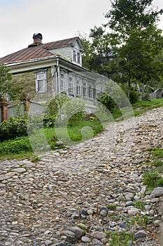 A steep stone-paved street with traditional wooden houses in the town of Ples, Russia