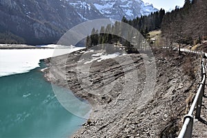 Steep stone shore and reflection of snowy panorama of Alps in KlÃÂ¶ntalersee lake