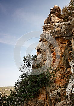 Steep weathered cliff face over dramatic sky