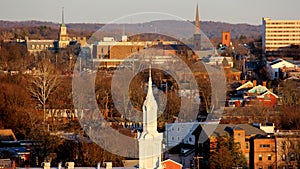 Steeple of the Church of Our Lady of Mt Carmel, downtown on the hillslope in the background, view at sunset, Poughkeepsie, NY