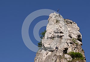 Steeple rock with cross Climbers trying reach peak