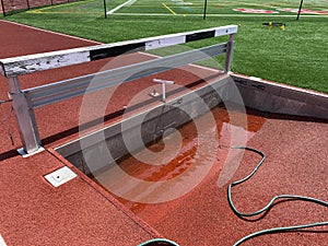 Steeplechase pit filling with water before a track meet