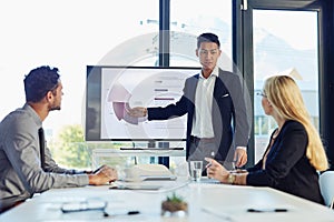 Steering the conference like a pro. a young businessman delivering a presentation to his colleagues in the boardroom of