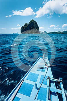 Steering local boat towards exotic island tour trip to the protected famous archipelago Bacuit El Nido, attractions