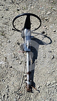 The steering wheel of a car dismantled and left on the ground.