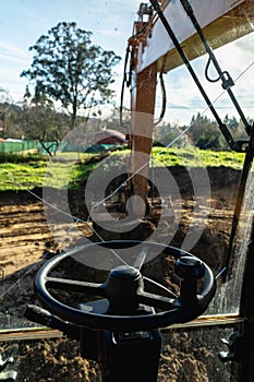 Steering wheel of an constuction industry heavy equipment yellow Excavator at Construction Site