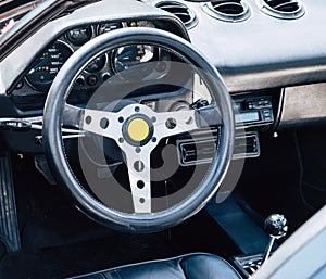 The steering wheel and dashboard of an antique classic car