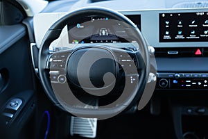 Steering wheel of electric vehicle, interior, cockpit, electric buttons. Autonomous car. Driverless car. Self-driving