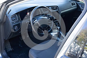 Steering wheel of a electric vehicle, interior cockpit, electric buttons, digital speedometer, front seats, textile