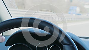 Steering wheel with hand during car driving on day highway