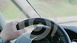 Steering wheel with hands during car driving on day highway