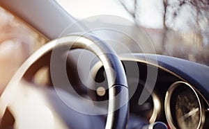 Steering wheel and the instrument panel on the dashboard of the car.