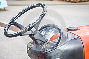 Steering wheel and levers inside tractor.