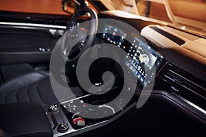 Steering wheel and navigation display. Close up view of front park of new modern black automobile
