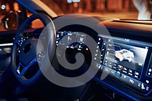 Steering wheel and navigation display. Close up view of front park of new modern black automobile