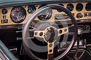Steering wheel, speedometer, revs, clock dials, radio scale, buttons and knobs on dashboard and front panel of old timer coupe