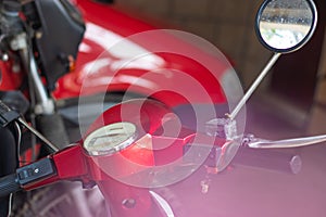 Steering wheel of a typical red italian old motorbike, pink glow, shooting through flowers