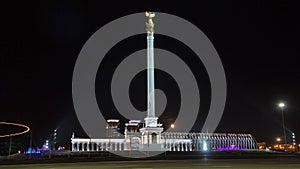 Stele monument Kazakh Eli with bird Samruk and Palace of Independence timelapse hyperlapse at night.