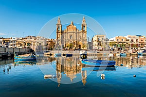 The Stella Maris church and its reflection on the Mediterranean Sea and its boats