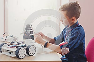 Stem education. Boy creating robot at lab