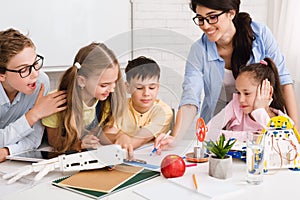 Stem education. Children studying at robotic class, making notes