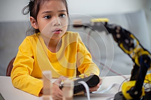 STEM education concept. Asian students learn at home by coding robot arms in STEM, mathematics engineering science technology