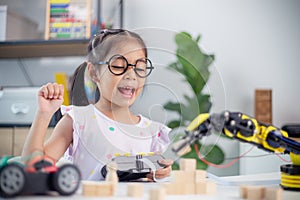 STEM education concept. Asian students learn at home by coding robot arms in STEM, mathematics engineering science technology