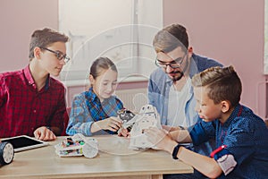 Stem education. Kids creating robots with teacher