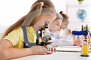 Stem education. Little girl looking at microscope