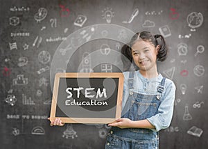 STEM Education on school teacher`s classroom chalkboard with smart girl kid student holding blackboard for science, technology