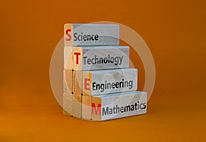 STEM science technology engineering mathematics symbol. Words STEM science technology engineering mathematics on orange background