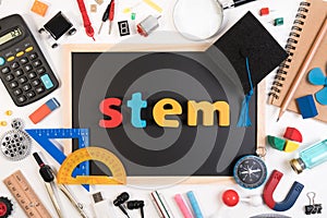 STEM word on blackboard with education equipment for background.