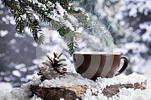 Steming hot drink in a cup outdoors on a tree stump