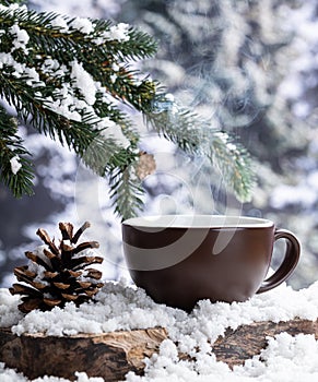 Steming hot drink in a cup outdoors on a tree stump