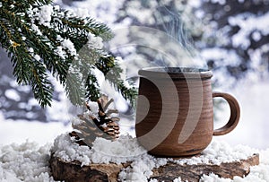 Steming hot drink in a mug outdoors on a tree stump